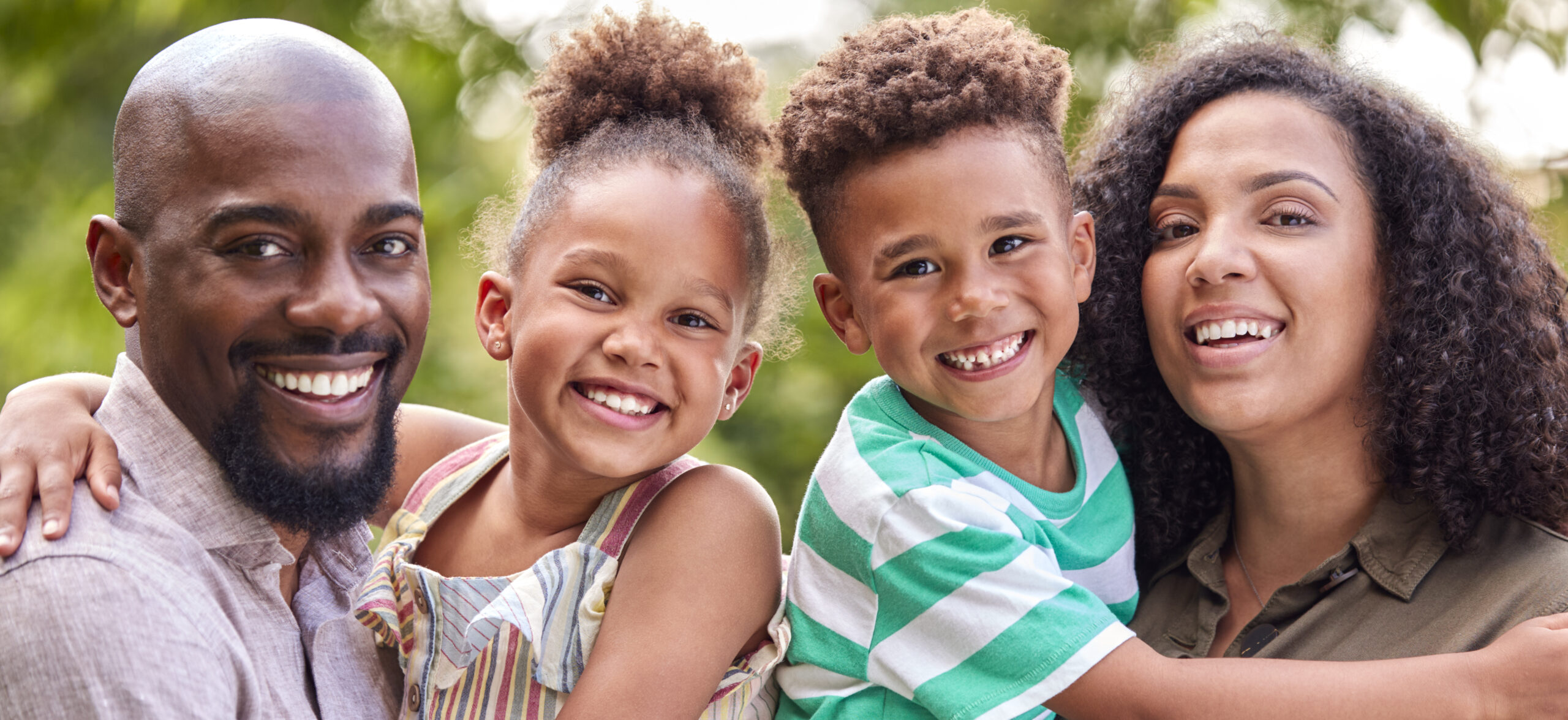 Portrait Of Smiling Family At Home Outdoors In Garden Together